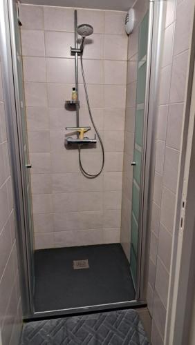 a shower with a glass door in a bathroom at chambre cocooning in Annappes