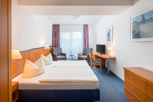 a hotel room with two beds and a desk at Gästehaus Gelsenkirchen in Norderney