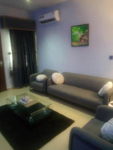 a living room with a couch and a coffee table at Zucchini Hotel and apartments in Umueme