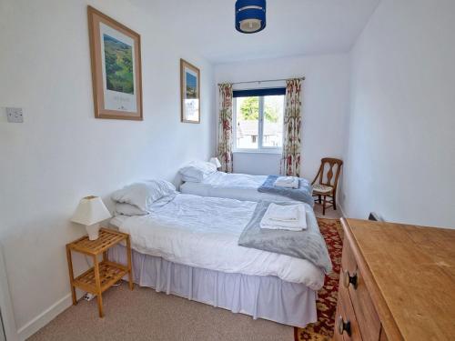 a bedroom with a bed and a table and a window at 3 Bed in Narberth FB138 in Narberth