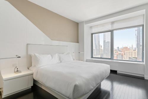 um quarto branco com uma cama grande e uma janela em Financial District 1br w WD gym elevator NYC-1368 em Nova York