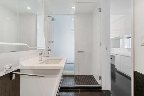 uma casa de banho branca com um lavatório e um chuveiro em Financial District 1br w WD gym elevator NYC-1368 em Nova York