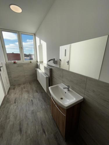 La salle de bains est pourvue d'un lavabo et d'un miroir. dans l'établissement CZARNA PERŁA, à Wrocław