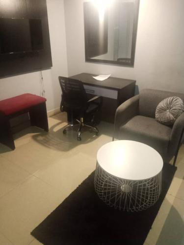 a living room with a couch and a desk at Zucchini Hotel and apartments in Umueme