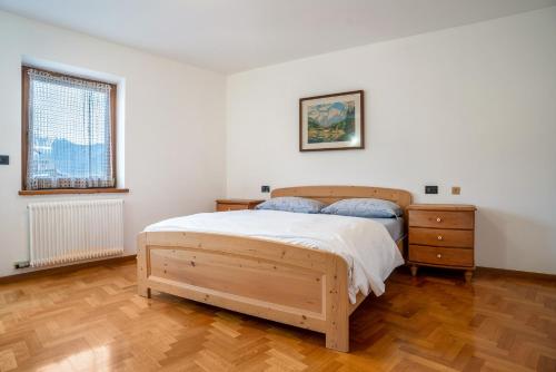 a bedroom with a wooden bed and a wooden floor at Casa al portico Val di Cembra in Grauno