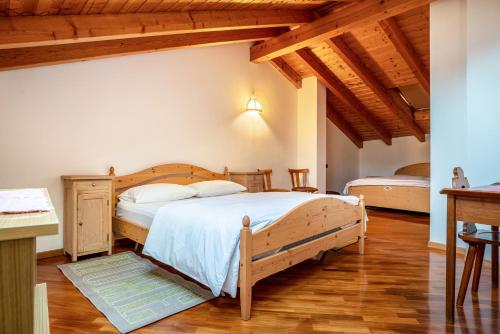 a bedroom with a large bed in a room with wooden ceilings at Casa al portico Val di Cembra in Grauno