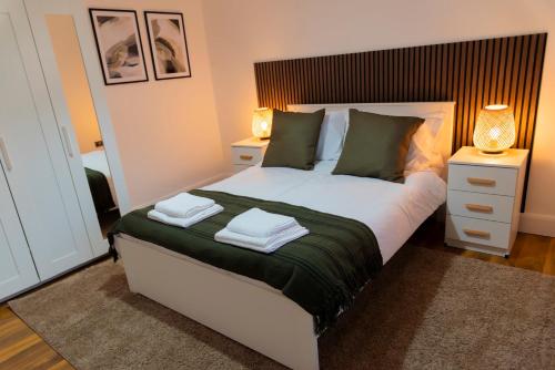a bedroom with a bed with two towels on it at Stylish 3 bedroom flat, free parking in London