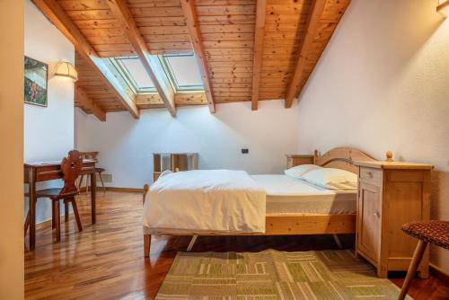 1 dormitorio con 1 cama y escritorio en una habitación en Casa al portico Val di Cembra, en Grauno