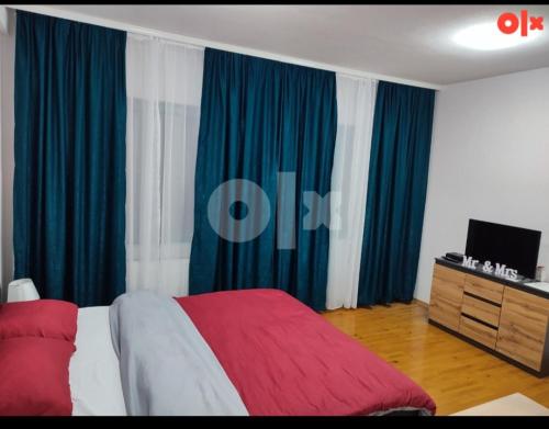 a bedroom with blue and white curtains and a bed at Atina apartman in Brčko