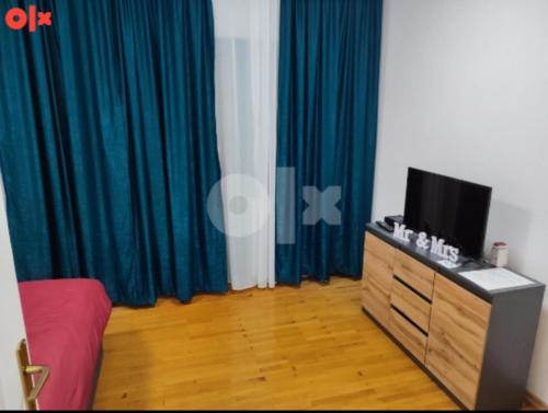 a room with a tv and a dresser with a television at Atina apartman in Brčko