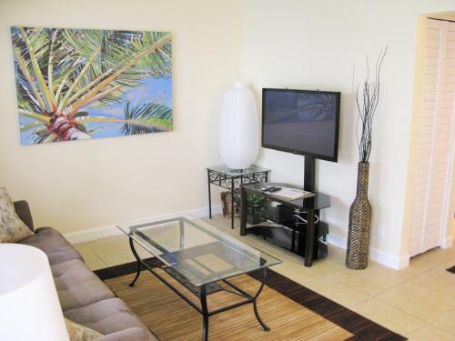 uma sala de estar com um sofá e uma televisão em Centrally located between downtown Fort Lauderdale, Airport and the Beach em Fort Lauderdale