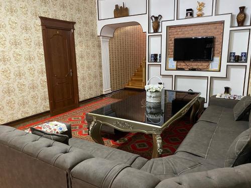 ein Wohnzimmer mit einem Sofa und einem Tisch in der Unterkunft Khiva Bibimariyam in Xiva