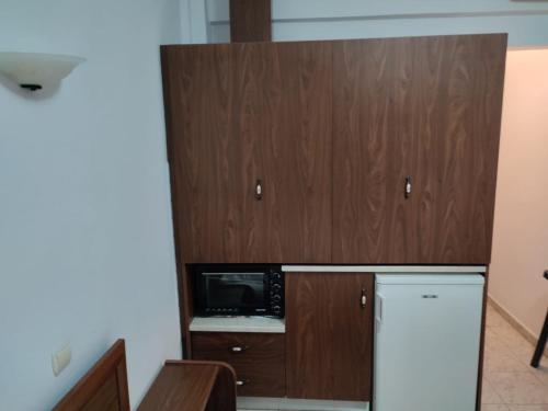 eine Küche mit einem Kühlschrank und einer Mikrowelle in der Unterkunft Ξενώνας Φωτεινη in Ouranoupoli