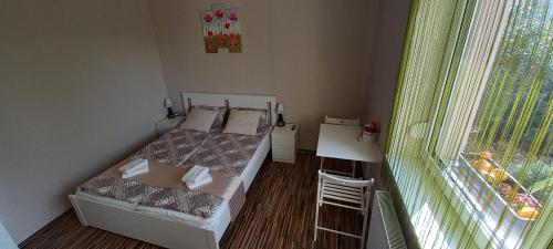 a small bedroom with two beds and a window at BarBen Apartman in Mórahalom