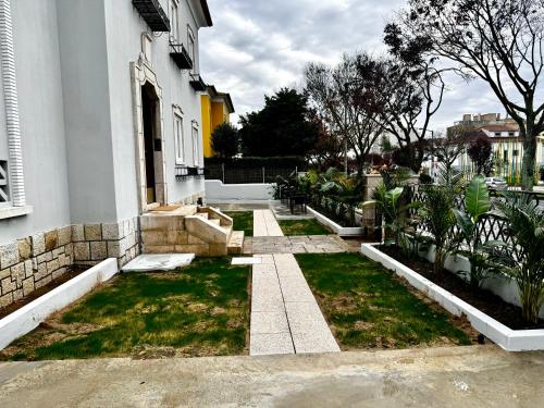 a house with a yard with grass and plants at Relax and Explore Lisbon Suites and Rooms in Lisbon