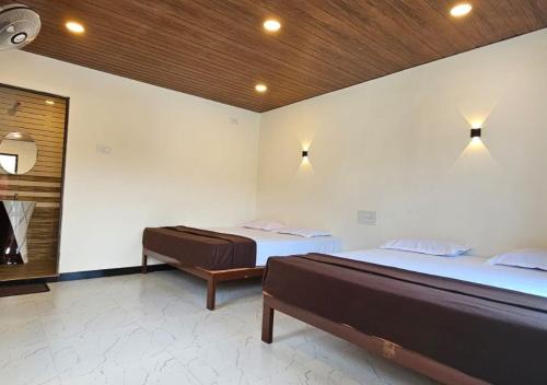 a bedroom with two beds and a window at Areca Jungle Stays by StayApart in Potolai