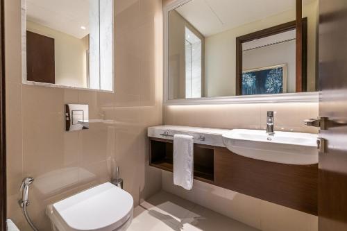 a bathroom with a sink and a toilet and a mirror at 1BDR in Madinat Jumeirah Living Close to Burj Al Arab in Dubai