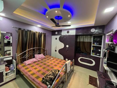 Schlafzimmer mit einem Bett und einer Decke mit blauem Licht in der Unterkunft Avena 2BHK Fully Furnished Flat Mid Of City Siliguri in Shiliguri