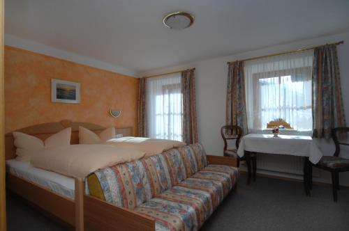 オーバーティリアッハにあるNaflerhofのベッドルーム1室(ベッド1台、ソファ、テーブル付)
