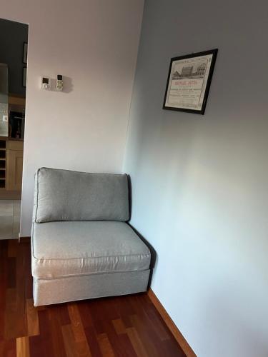 a gray couch sitting in a room with a wall at 4 All Apart Hotel in Swarzędz