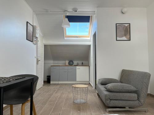 a living room with a couch and a table at Appartements proches CDG Le Bourget dans maison francilienne typique in Le Blanc-Mesnil