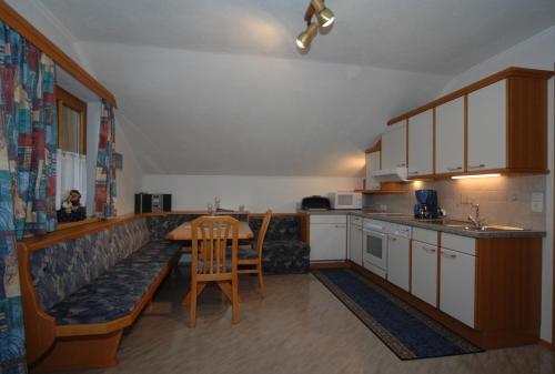 eine Küche mit einem Tisch, einem Sofa und einem Tisch in der Unterkunft Naflerhof in Obertilliach