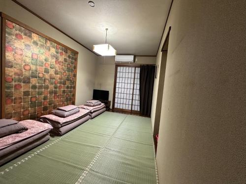 een kamer met drie bedden en een raam bij Minato Oasis Numazu / Vacation STAY 40706 in Numazu