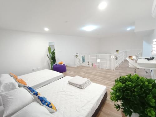 Habitación blanca con 2 camas y lavamanos en Arte Cheras Duplex Near MRT 1 en Kuala Lumpur