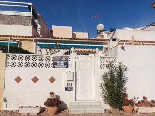 a white fence with a gate and a door at Charming Bungalow in Torrevieja Near La Mata Natural Park in La Mata