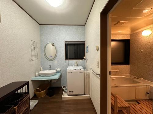een badkamer met een wastafel en een bad bij Minato Oasis Numazu / Vacation STAY 40706 in Numazu