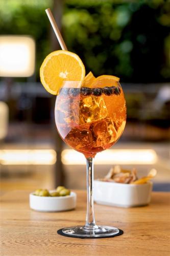 a drink with an orange slice on a table at InterContinental Santiago by IHG in Santiago