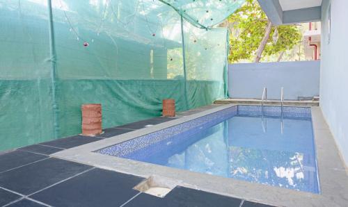 - une piscine dans un bâtiment doté d'un mur en plastique dans l'établissement Itsy By Treebo - Raj Resort, Calangute, à Calangute