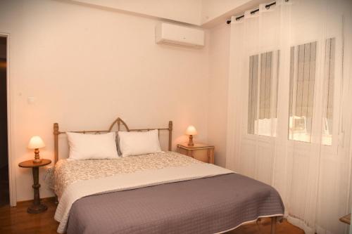 een slaapkamer met een bed met 2 tafels en 2 lampen bij Ellis house in Agrinion