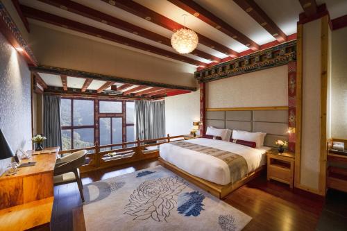 a bedroom with a large bed and a desk at Willing Resort, Trongsa in Kagha