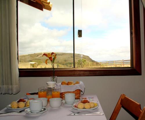 a breakfast table with a view of the ocean from a window at Pousada Gaya in Carrancas