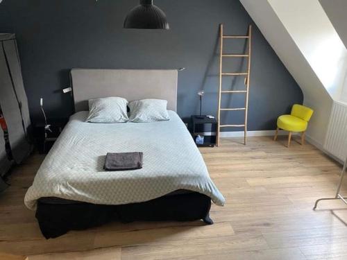 - une chambre avec un lit avec une échelle et une chaise jaune dans l'établissement Maison Familiale Saint-Malo, à Saint-Malo