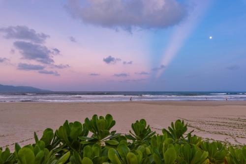 a view of a beach with people in the ocean at Danang Pool Villas Resort & Spa My Khe Beach in Danang