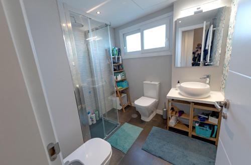 La salle de bains est pourvue de toilettes, d'un lavabo et d'une douche. dans l'établissement Habitaciones Privadas en mi acogedor Chalet - Private rooms, à Madrid