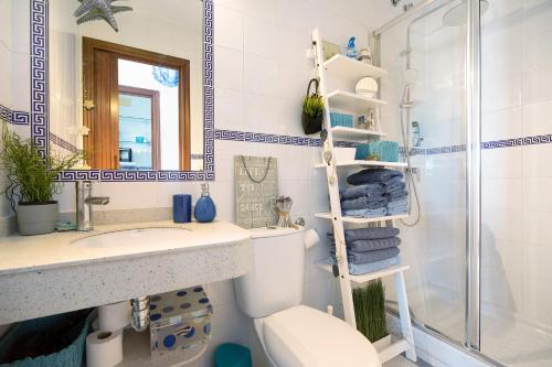 a bathroom with a toilet and a sink and a shower at Apartamento La Barca - Chipiona in Chipiona