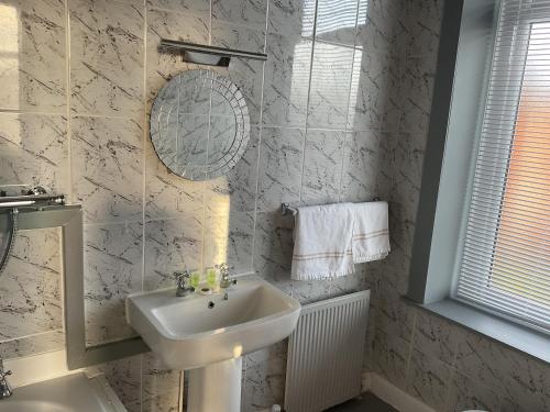 Baño blanco con lavabo y espejo en The Claremont Preston, en Preston