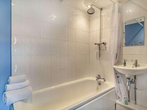 a white bathroom with a tub and a sink at 2 Bed in Bacton 86430 in Bacton
