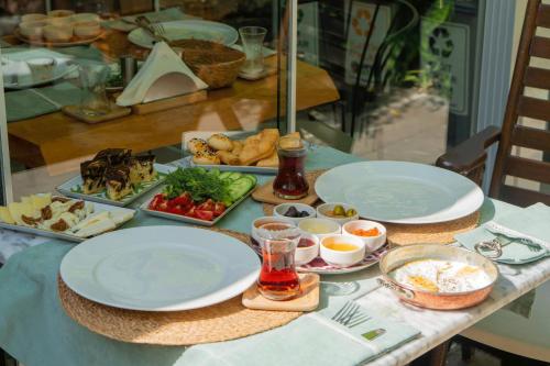 una mesa con platos y tazones de comida. en Cunda Ilios Hotel, en Ayvalık