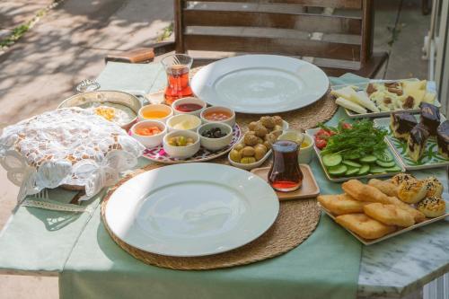 una mesa con platos de comida en una mesa en Cunda Ilios Hotel en Ayvalık