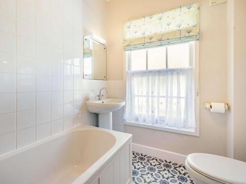 a bathroom with a tub and a sink and a toilet at 2 Bed in Newby Bridge 87621 in Newby Bridge