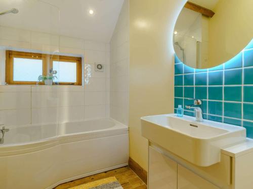 a bathroom with a sink and a tub and a mirror at 3 bed in Usk 87286 in Llandenny