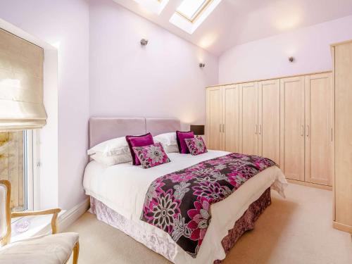 a white bedroom with a large bed with purple pillows at 1 bed in Lytham St. Annes 88141 in Saint Annes on the Sea
