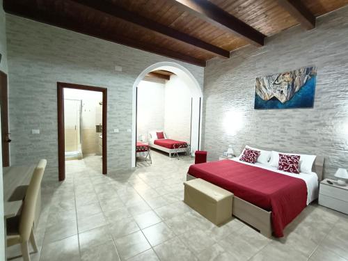 a bedroom with a bed with a red blanket at Domos La Corte Ghibellina in Iglesias