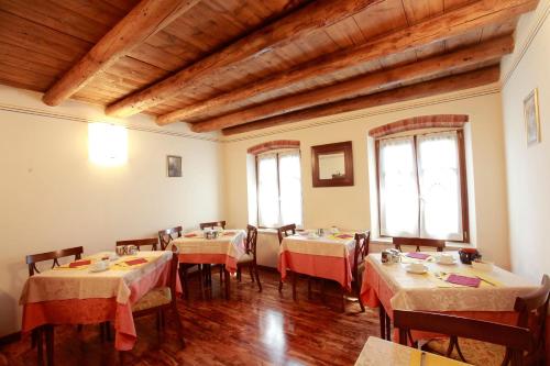una sala da pranzo con tavoli, sedie e soffitti in legno di Locanda da Bepi a Marano di Valpolicella