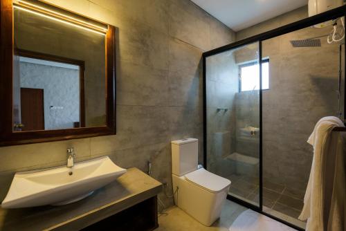 a bathroom with a sink and a toilet and a shower at Grand Beragala Boutique Resort in Beragala