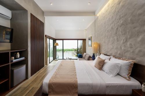 Grand Beragala Boutique Resort في Beragala: غرفة نوم كبيرة مع سرير كبير مع وسائد بيضاء